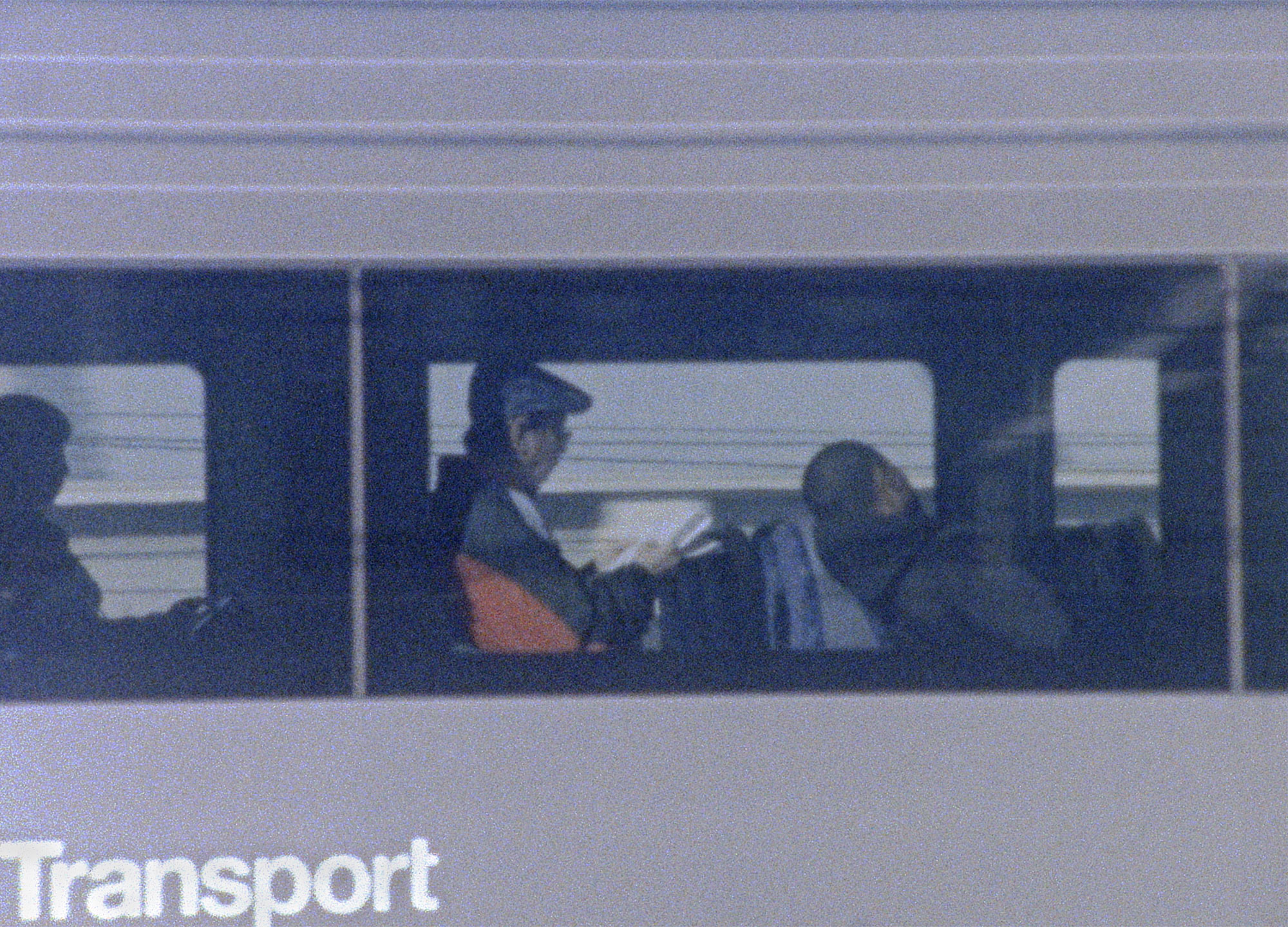 A man sitting on a train reading a newspaper
